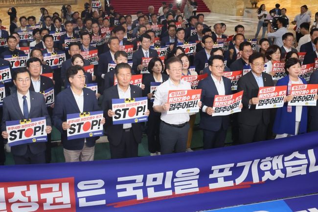 더불어민주당 이재명 대표와 박광온 원내대표 등이 31일 오후 국회 로텐더홀에서 열린 긴급 의원총회에서 구호를 외치고 있다.