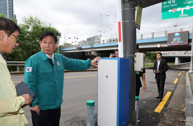 박강수 마포구청장이 자동 차단 시스템이 내장된 차량 통제 차단기를 살피고 있다
